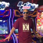 Rick Baltman in front of a bank of MotoGP arcade games