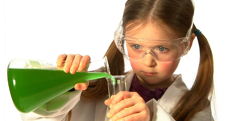 a girl in a lab coat doing a science experiment