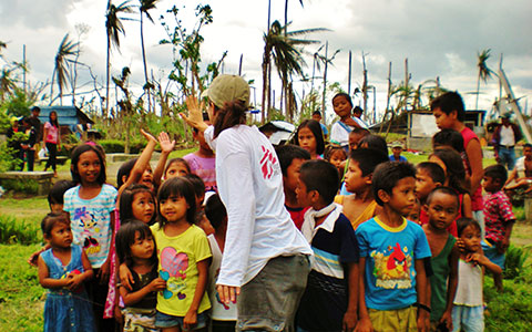 Sara Badiei high-fives villagers in the Philippines
