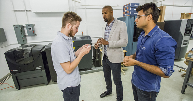 Kai James with graduate students in a lab